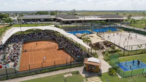Vista aérea de um conjunto de quadras cobertas e descobertas com arquibancada tensionada